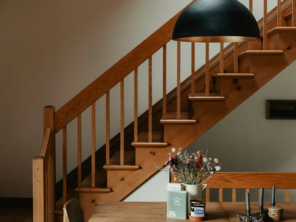 Houten trap met spijlen en een houten leuning in een woonruimte