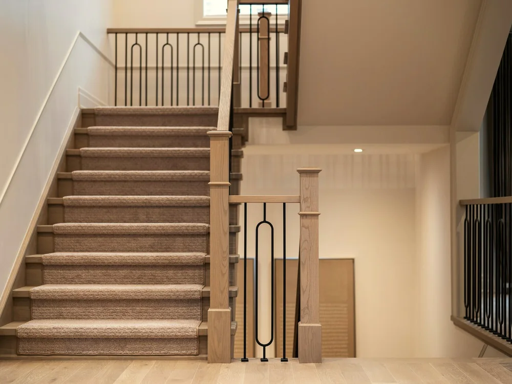 Gestoffeerde trap naar een overloop met balustrade