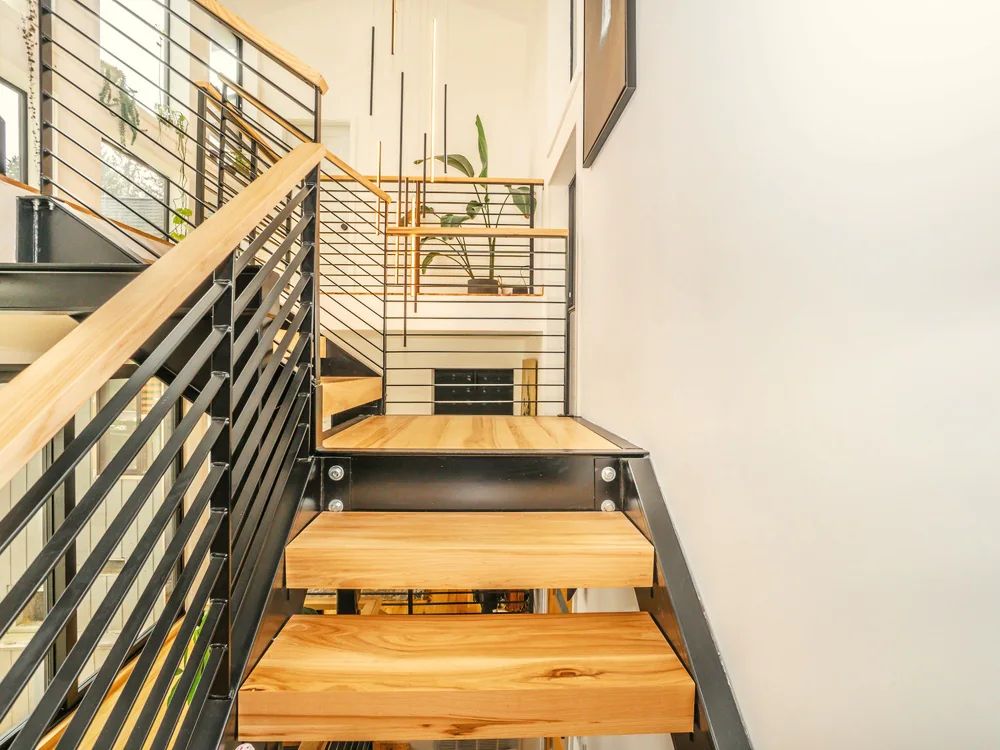 Trap met houten treden en een zwarte stalen balustrade