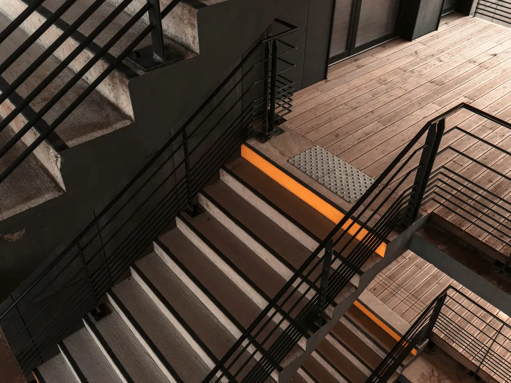 Trap met stalen balustrade en houten treden, met licht onder de treden