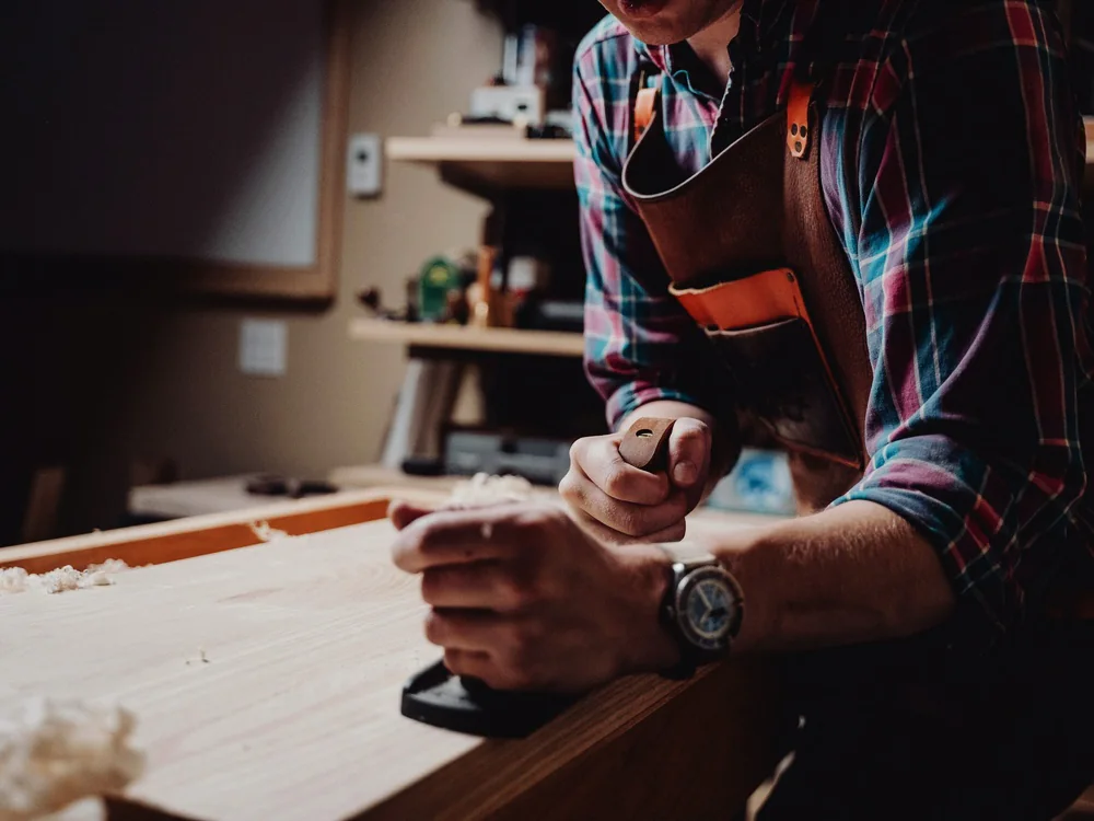 Vakman schaaft een houten plank in de werkplaats